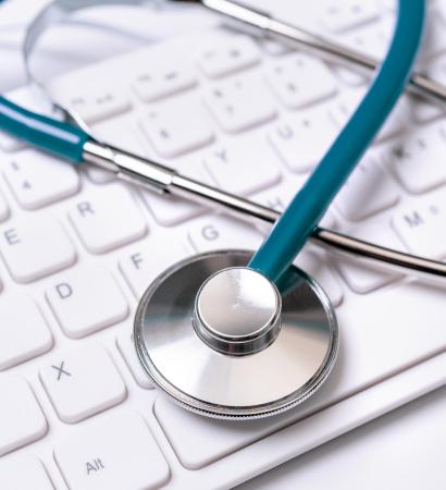 Stethoscope on computer keyboard on white background. Physician write medical case long term care treatment concept, close up, macro, copy space Stethoscope on computer keyboard on white background. Physician write medical case long term care treatment concept, close up, macro, copy space